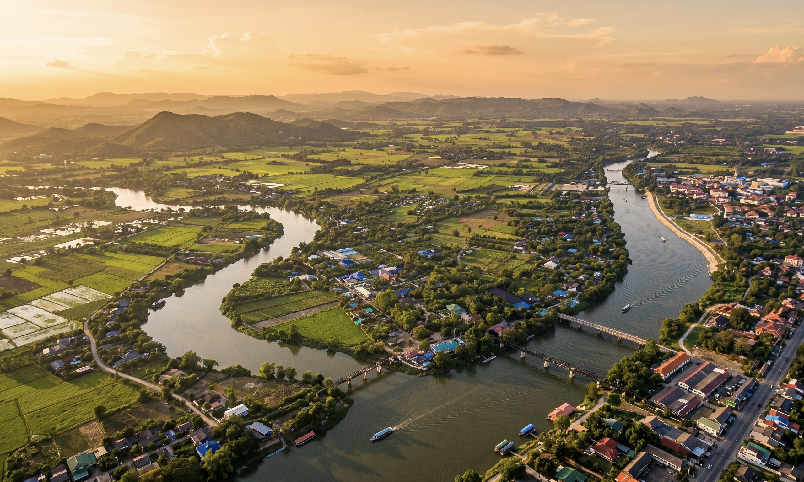 Aerial view of the Ratchaburi river valley — lush green flatlands and coconut farms, golden hour